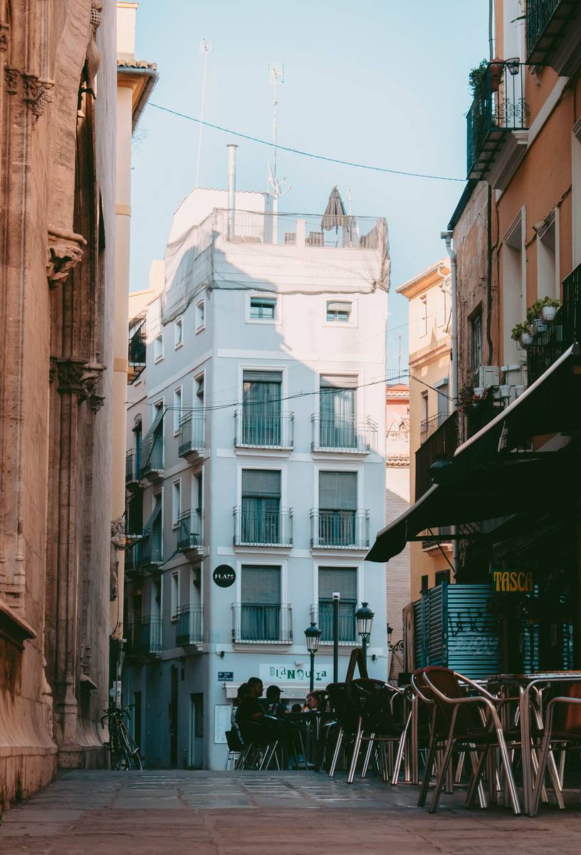Calle angosta con bares y mesas afuera