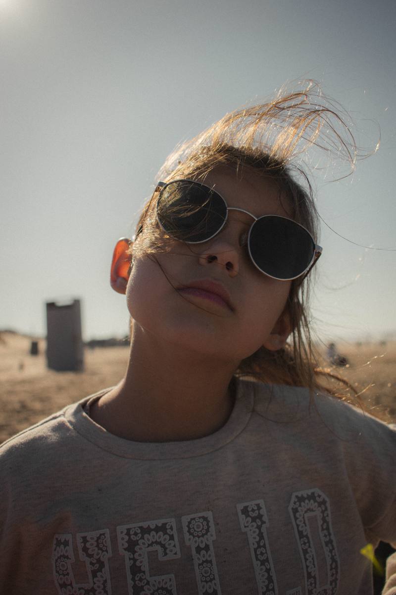 Retrato de una nena con anteojos de sol en la playa